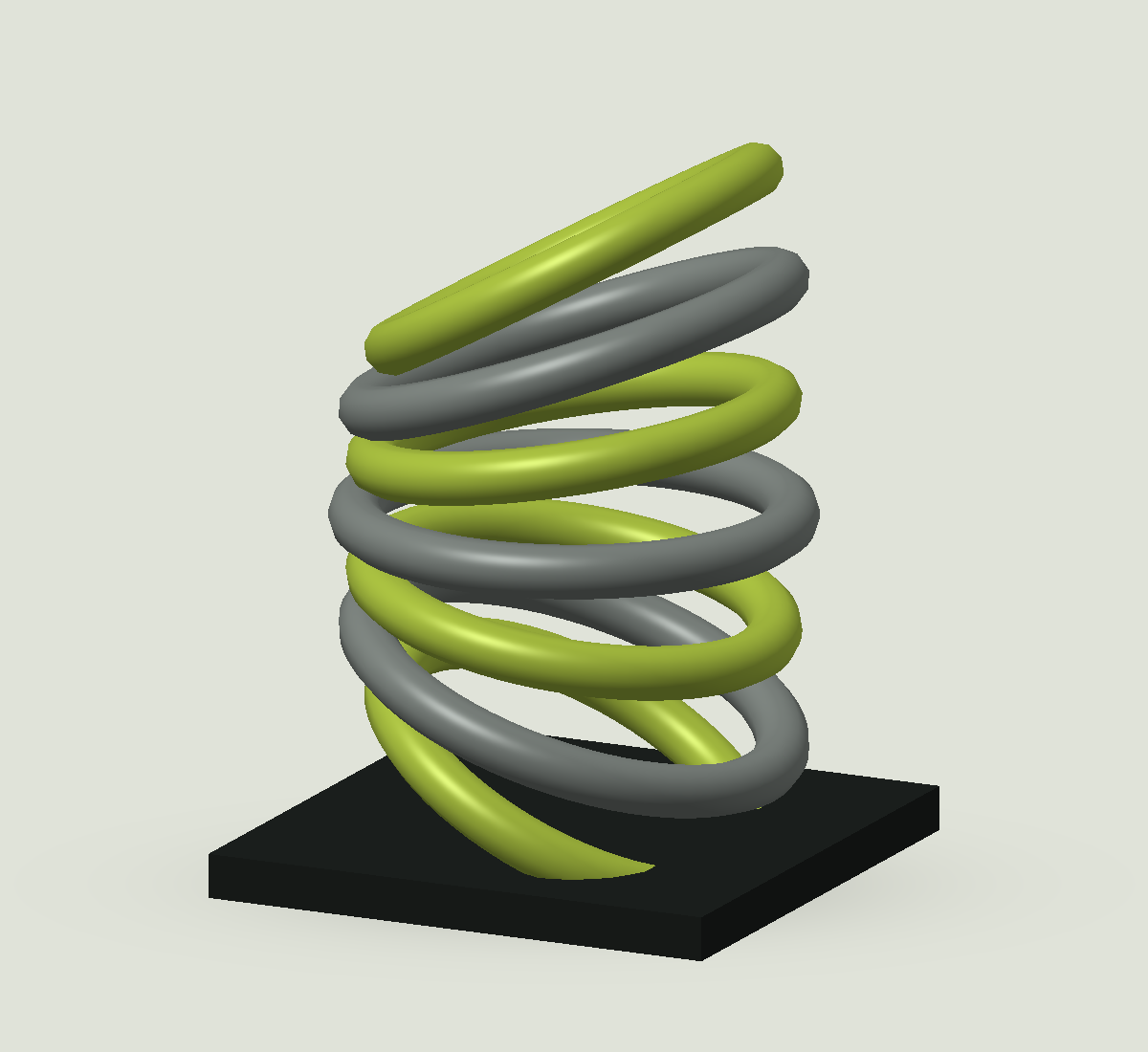 Een sculpturale stapeling van groene en metalen ringen op een donkere vierkante voet.